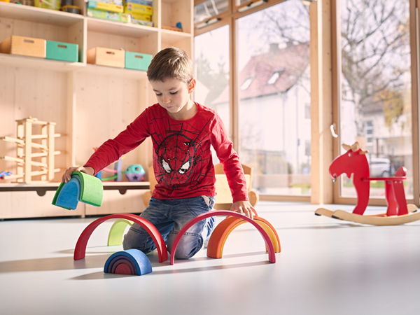 Kita-Kind spielt auf dem Fußboden