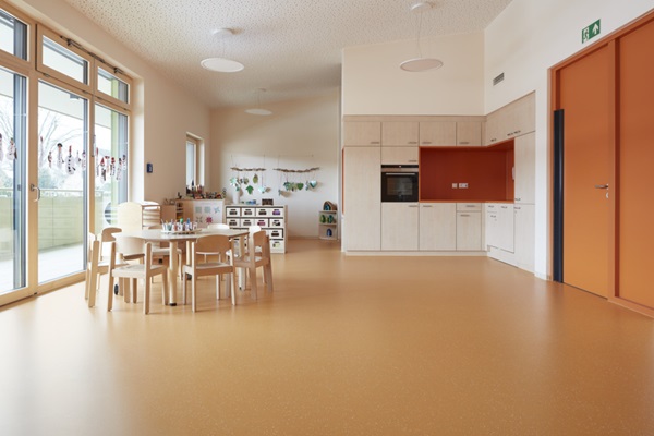 wohnlicher Gruppenraum Kita ZuS mit orangenem noraplan signa Bodenbelag