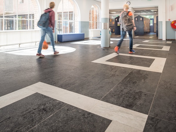 Newly renovated historical school building: Pupils in the lobby on rubber flooring in slate-look, installed in pattern