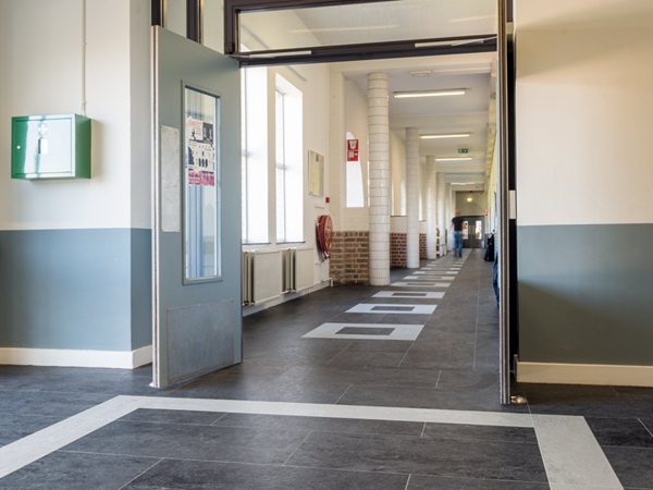 school corridor with rectangular floor pattern made of half tiles and quarter tiles of norament arago rubber floor covering