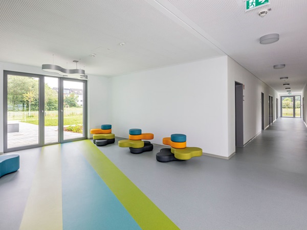 Fußbodengestaltung mit Regenbogenstrahlen: noracare Bodenbelag in der LWL Jugendpsychiatrie Dortmund