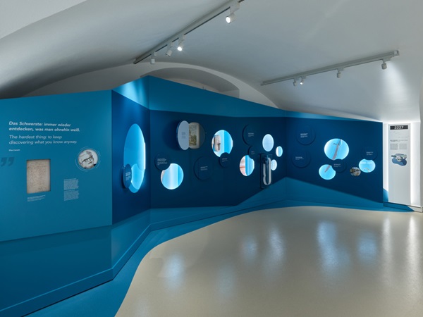 Raumgestaltung zum Thema Wasser: In der dunkelblauen Wand erinnern runde Guckfenster an Blasen, das Blau beginnt bereits davor, wo der Boden von beige zu blau wechselt